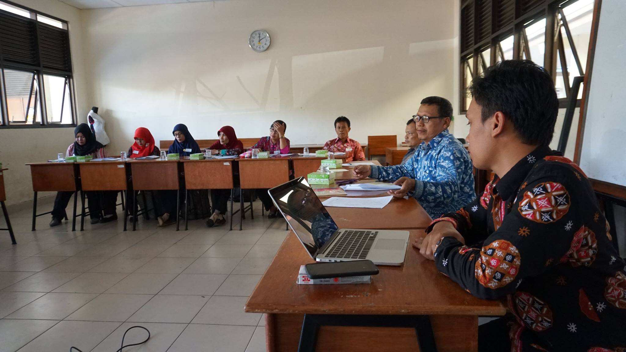 Diskusi para guru berpakaian batik di ruang kelas